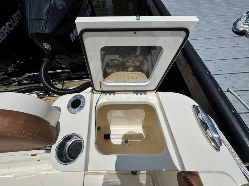 Slide: The Image of 2024 Scout 277 LXF boat with open storage compartment and Mercury engine. - 15