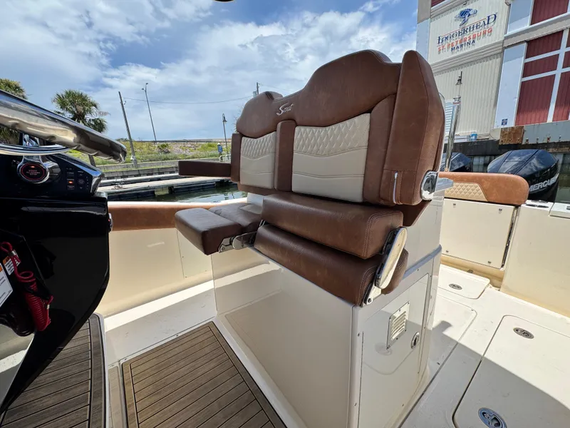 Slide: The Image of 2024 Scout 277 LXF boat interior with luxurious brown seating and modern dashboard. - 19