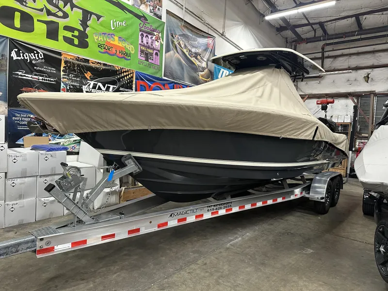 Slide: The Image of 2024 Scout 277 LXF boat covered on trailer in indoor storage. - 2