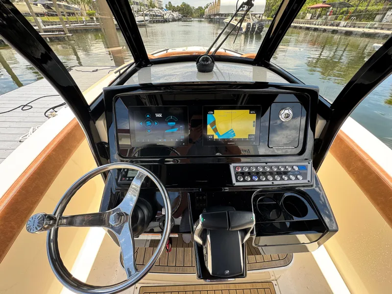 Slide: The Image of 2024 Scout 277 LXF boat dashboard with steering wheel and navigation screens. - 20