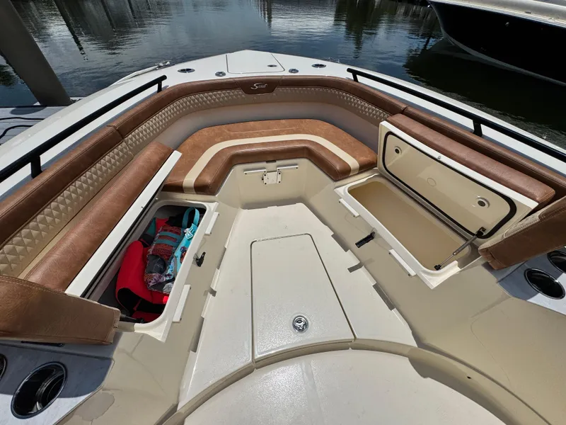 Slide: The Image of 2024 Scout 277 LXF boat interior with brown seating and storage compartments. - 25