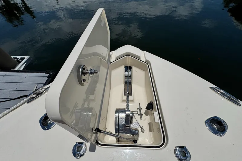 Slide: The Image of 2024 Scout 277 LXF boat anchor compartment open, dockside view. - 27