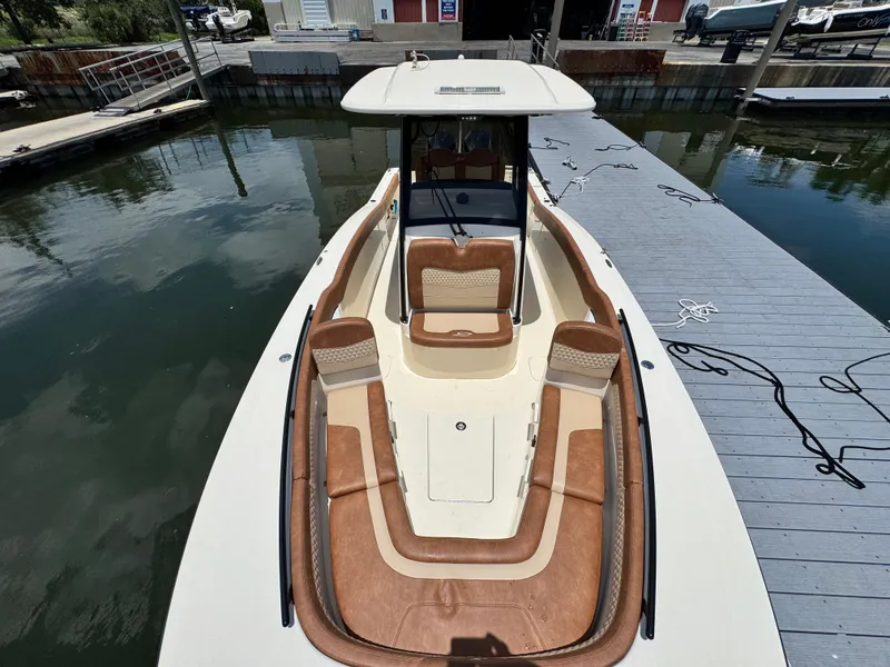 Slide: The Image of 2024 Scout 277 LXF boat docked, featuring spacious seating and sleek design. - 28