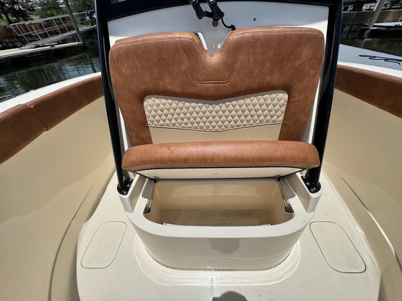 Slide: The Image of 2024 Scout 277 LXF boat interior with tan leather seating and storage compartment. - 29
