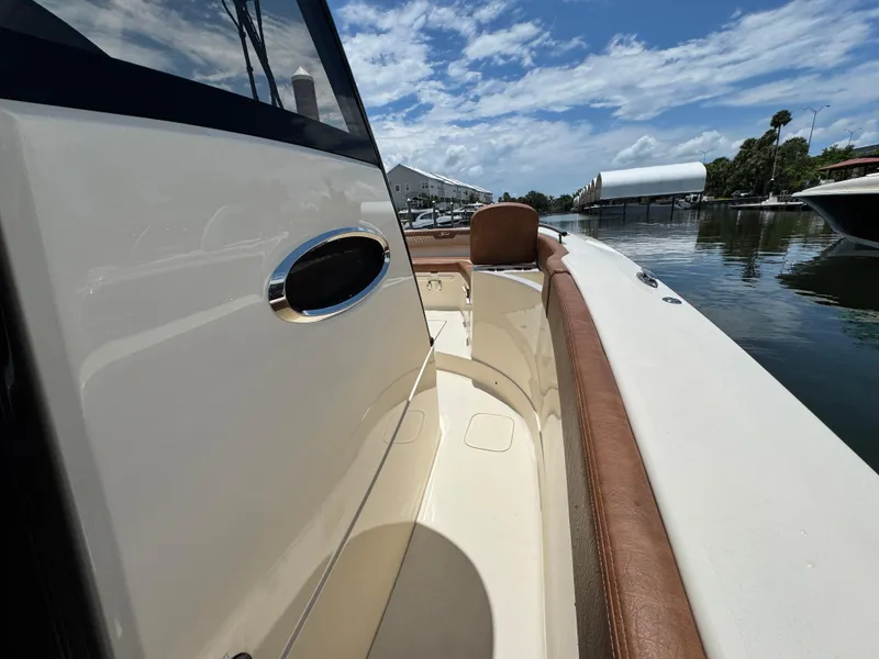 Slide: The Image of 2024 Scout 277 LXF boat interior with brown seating, docked by calm waters. - 30