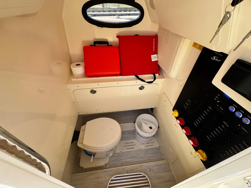 Slide: The Image of 2024 Scout 277 LXF boat interior with toilet, storage, and control panel. - 31