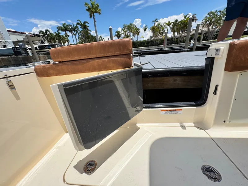 Slide: The Image of 2024 Scout 277 LXF boat with open side door, dockside view. - 32