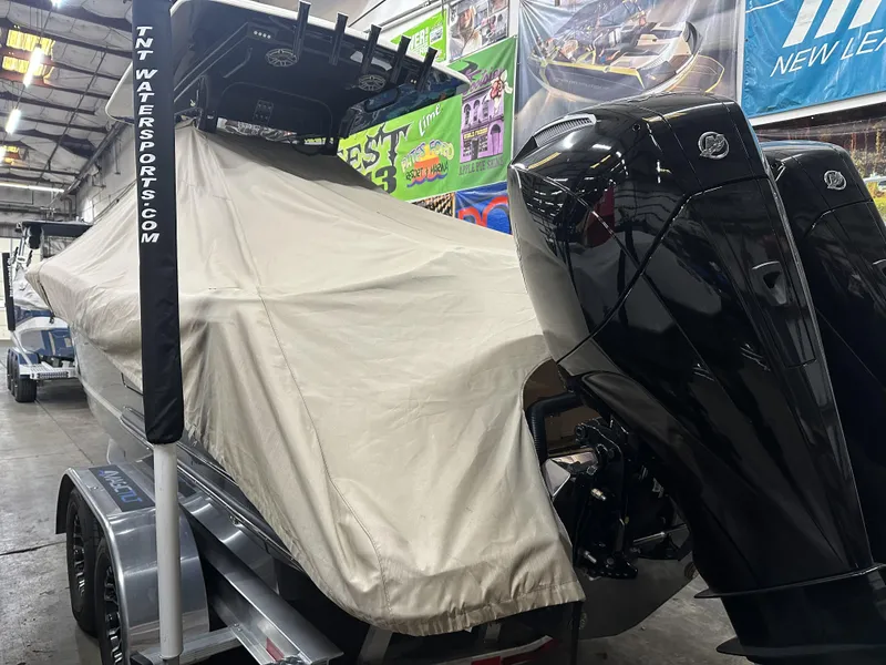 Slide: The Image of 2024 Scout 277 LXF boat covered in a garage with visible outboard motors. - 40