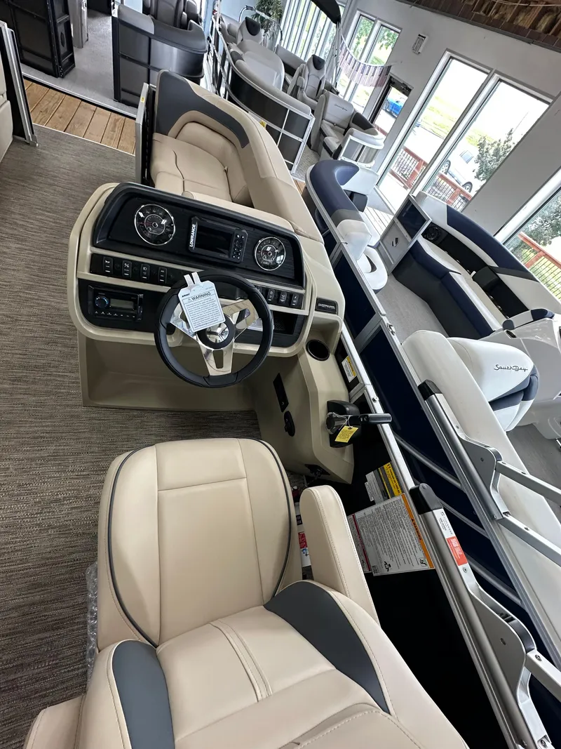 Slide: The Image of 2025 Godfrey Sweetwater 2086 SBC pontoon boat interior with beige seating and modern dashboard. - 3