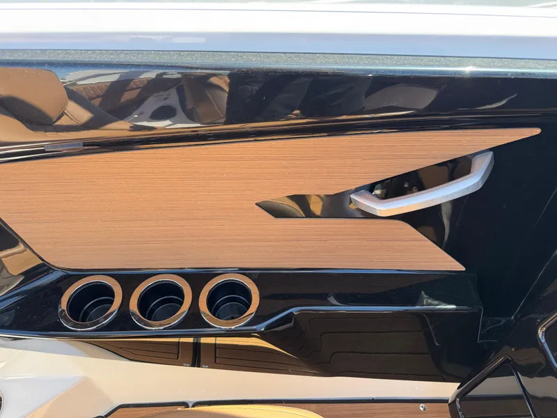 Slide: The Image of Interior detail of 2025 Yamaha Boats 222SD, featuring sleek wood paneling and cup holders. - 13