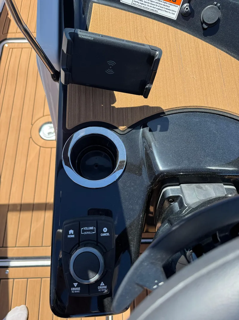 Slide: The Image of Control panel of 2025 Yamaha Boats 222SD, featuring cup holder and wireless phone charger. - 18