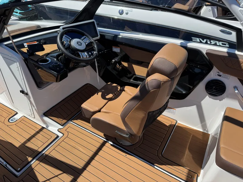 Slide: The Image of 2025 Yamaha Boats 222SD cockpit with modern steering wheel and brown seating. - 9
