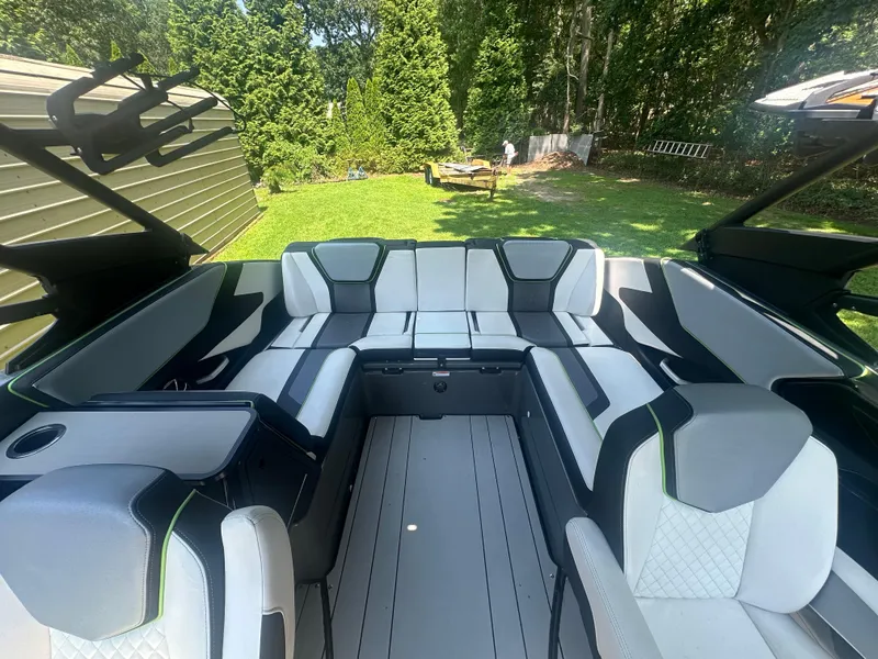 Slide: The Image of 2021 Yamaha Boats 255XD interior with sleek seating and modern design in a garden setting. - 13