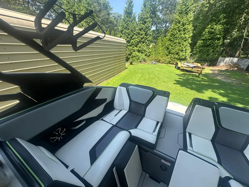 Slide: The Image of Interior of 2021 Yamaha Boats 255XD with sleek seating and lush green background. - 15