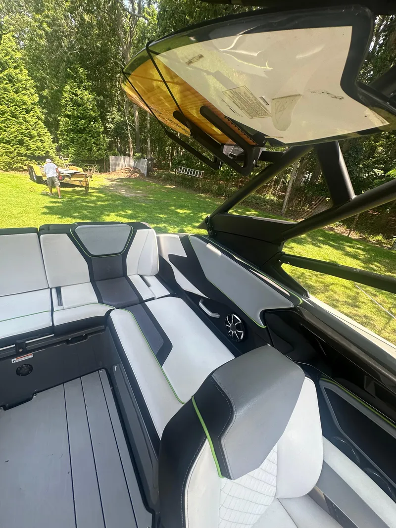 Slide: The Image of 2021 Yamaha Boats 255XD interior with sleek seating and modern design in a grassy outdoor setting. - 18