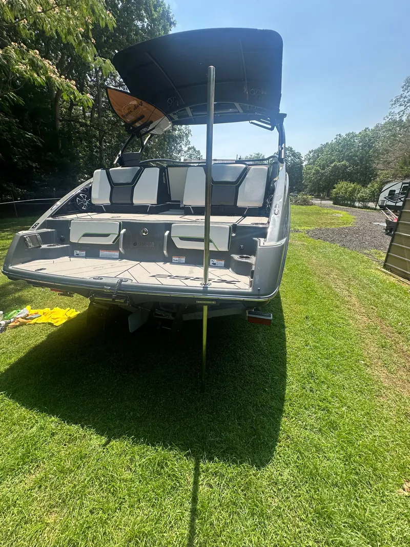 Slide: The Image of 2021 Yamaha Boats 255XD on grass, rear view with canopy and seating. - 21