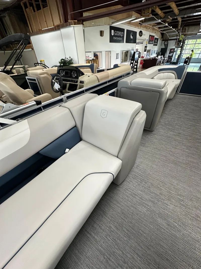Slide: The Image of 2025 Godfrey Sweetwater 2286 C pontoon boat interior with luxurious seating in showroom. - 11