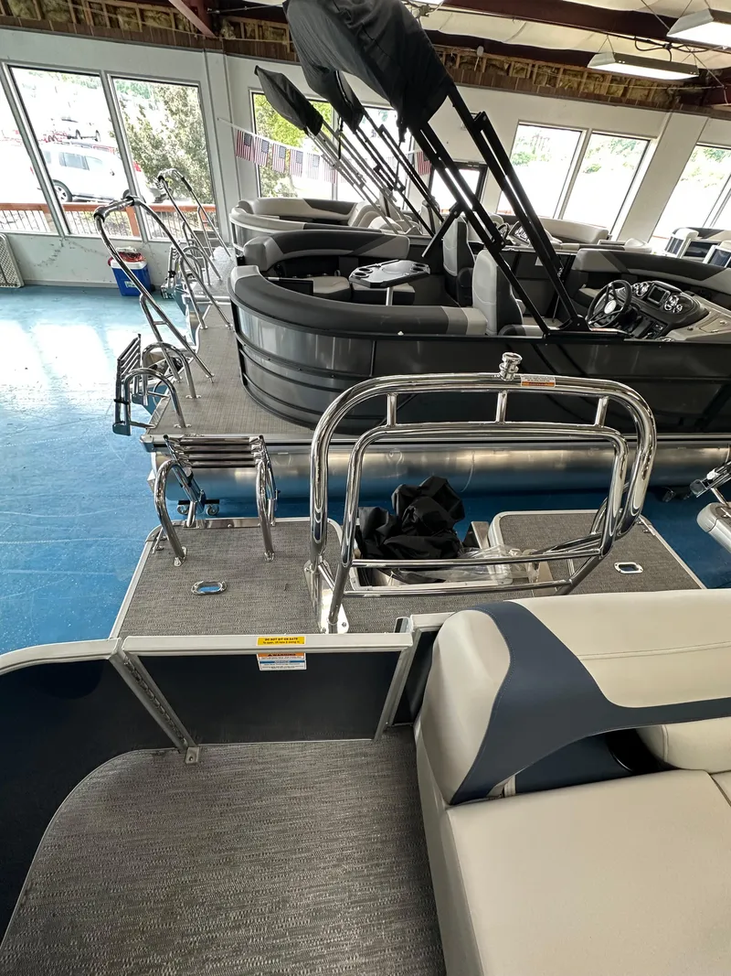 Slide: The Image of 2025 Godfrey Sweetwater 2286 C pontoon boat interior with seating and railing in showroom. - 12