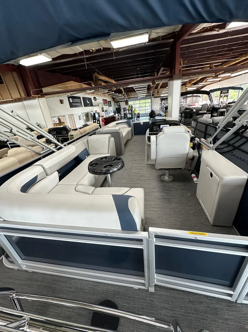 Slide: The Image of 2025 Godfrey Sweetwater 2286 C pontoon boat interior with seating and helm in showroom. - 13