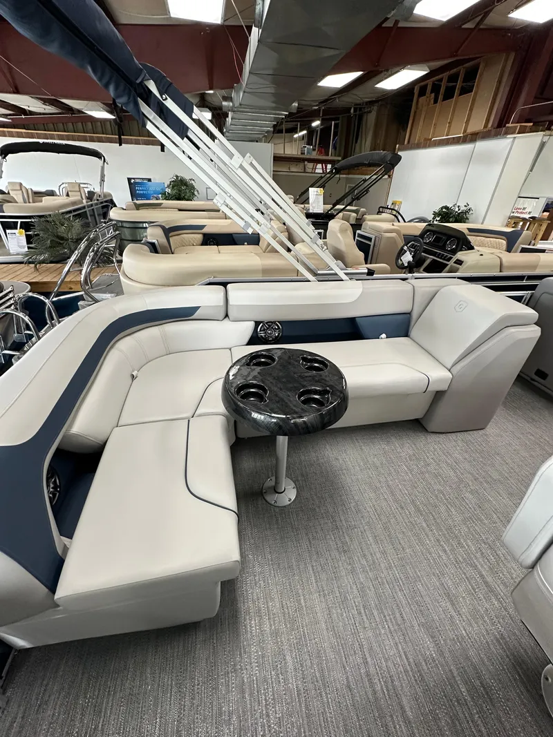 Slide: The Image of 2025 Godfrey Sweetwater 2286 C SPEC EDI TRI pontoon boat interior with plush seating and table. - 9