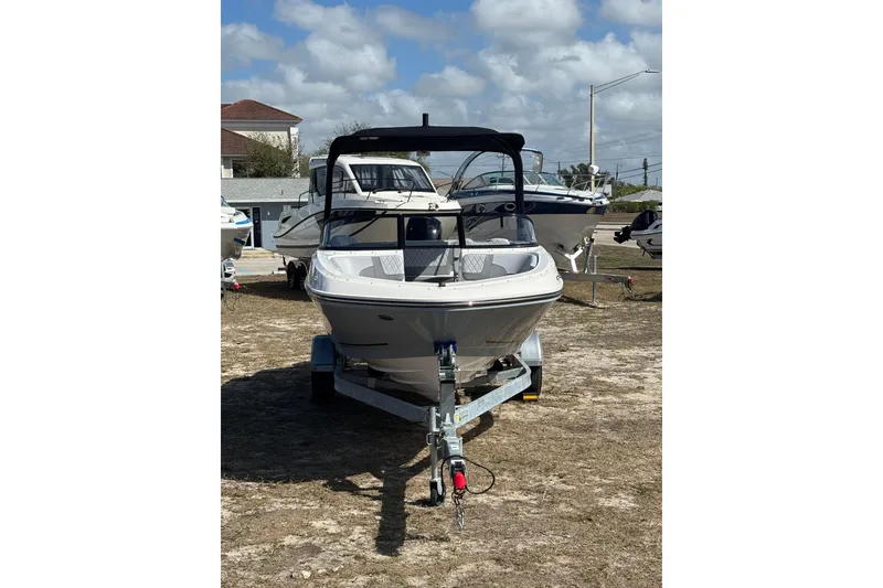 Slide: The Image of 2025 Bayliner VR5 Bowrider OB on trailer, parked outdoors under a cloudy sky. - 20