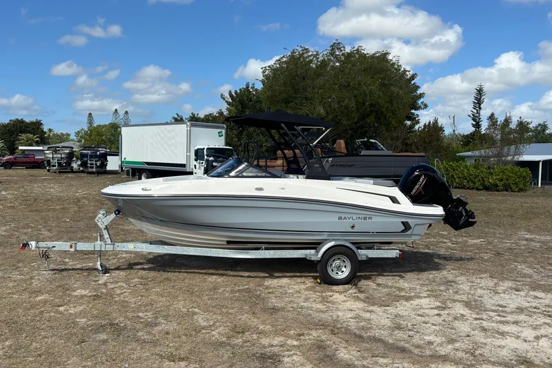 Slide: The Image of 2025 Bayliner VR5 Bowrider OB on trailer, parked outdoors under a blue sky. - 22