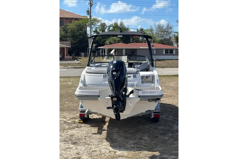 Slide: The Image of 2025 Bayliner VR5 Bowrider OB, rear view with outboard motor, parked on grass. - 24