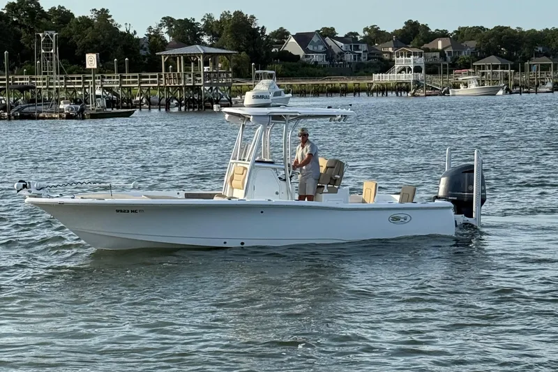 Slide: The Image of 2017 Sea Hunt BX 25 BR boat on water near docks and houses. - 12