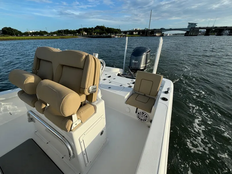 Slide: The Image of 2017 Sea Hunt BX 25 BR boat on water, featuring tan seating and powerful outboard motor. - 7
