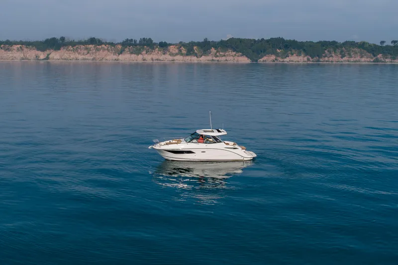 Slide: The Image of 2019 Sea Ray Sundancer 320 yacht cruising on calm blue waters. - 23