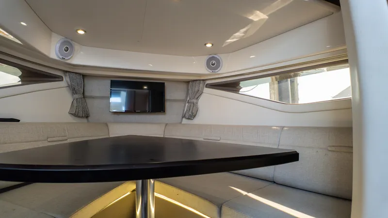 Slide: The Image of Interior of 2019 Sea Ray Sundancer 320 yacht with seating, table, and TV. - 33