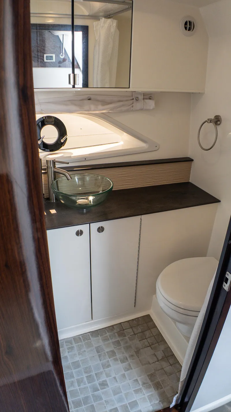 Slide: The Image of 2019 Sea Ray Sundancer 320 bathroom with modern sink, toilet, and storage cabinets. - 37