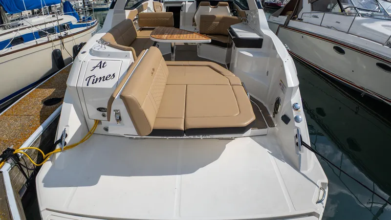 Slide: The Image of 2019 Sea Ray Sundancer 320 yacht with tan seating and wooden table, docked at marina. - 39