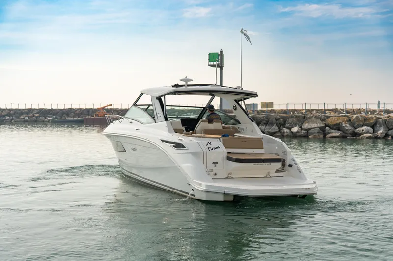 Slide: The Image of 2019 Sea Ray Sundancer 320 cruising near rocky shoreline under blue sky. - 6