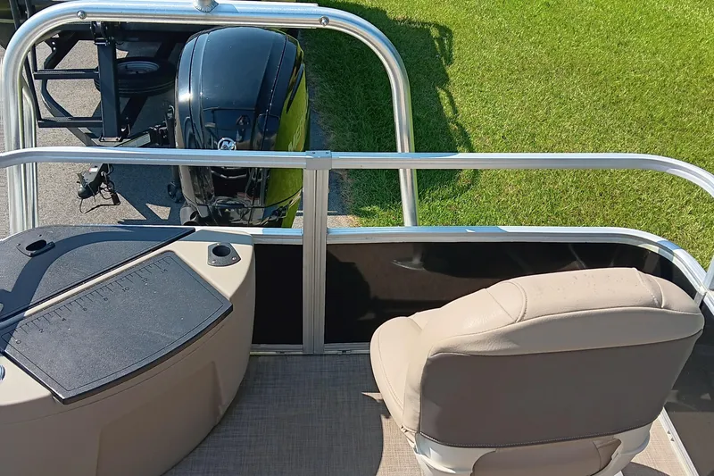 Slide: The Image of 2021 Sun Tracker Fishin' Barge 20 DLX boat interior with motor and seating. - 13