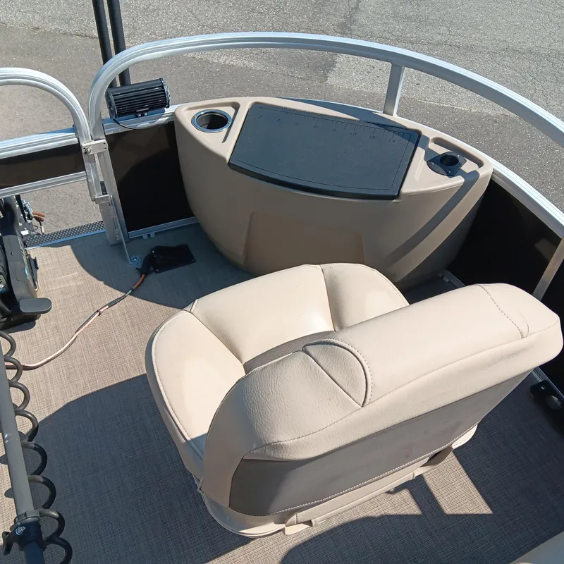 Slide: The Image of 2021 Sun Tracker Fishin' Barge 20 DLX interior with beige seating and control panel. - 8