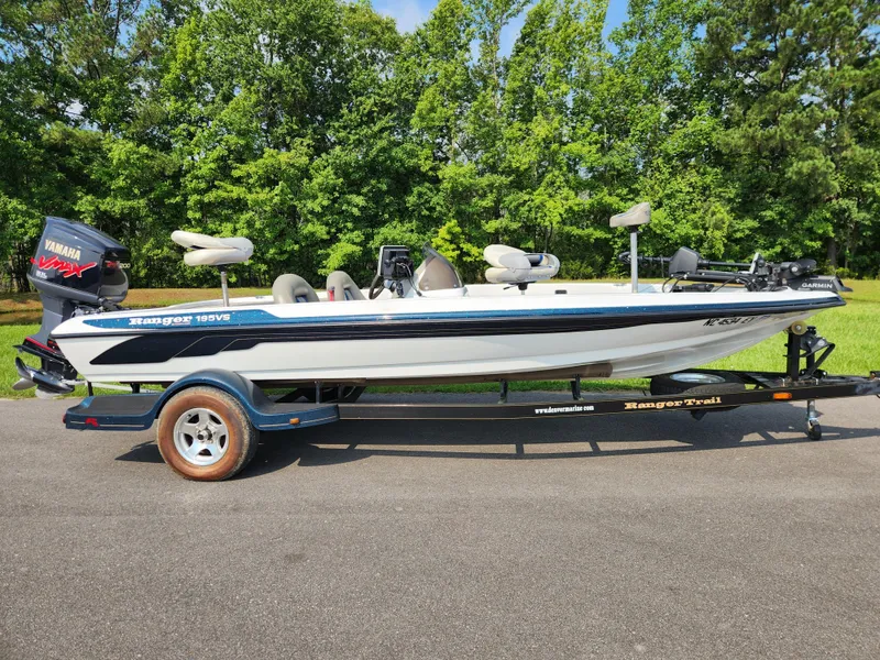 Slide: The Image of 2003 Ranger 195SVS boat on trailer, Yamaha engine, parked on road with green trees in background. - 0