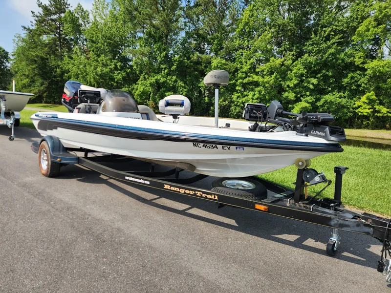 Slide: The Image of 2003 Ranger 195SVS boat on trailer, parked on road with green trees in background. - 1