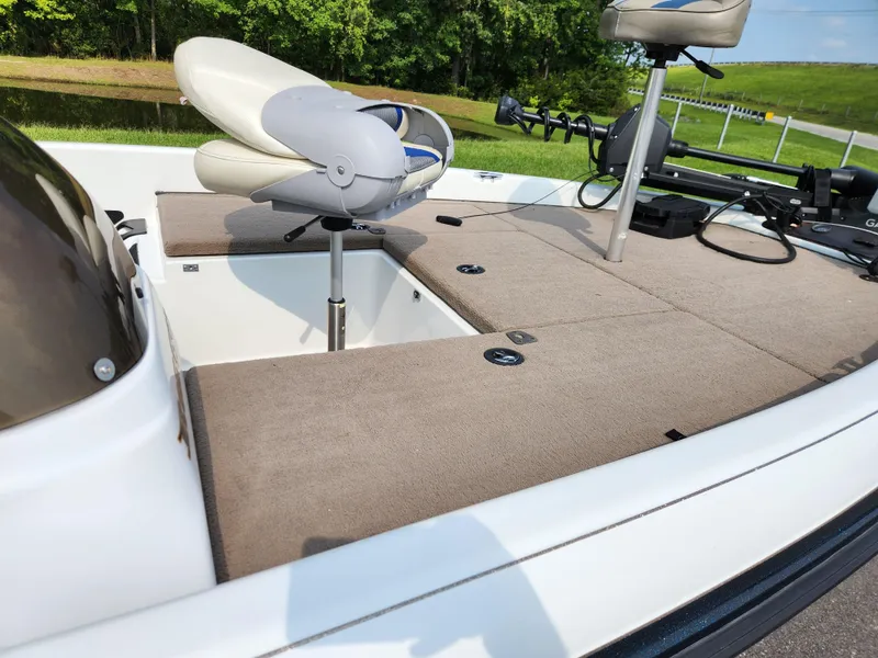 Slide: The Image of 2003 Ranger 195SVS boat interior with seating and fishing equipment on a sunny day. - 8