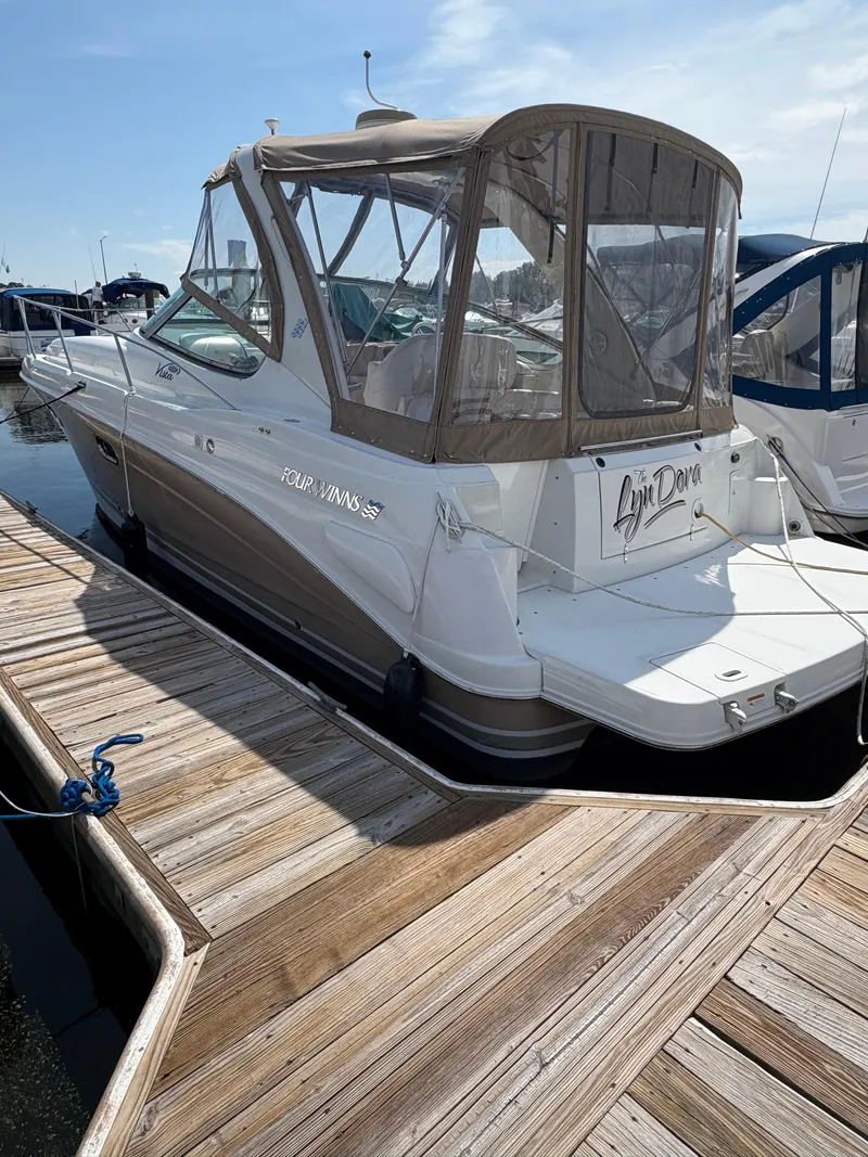 The Image of 2005 Four Winns 328 Vista Cruiser docked at marina, featuring enclosed cockpit. - 0