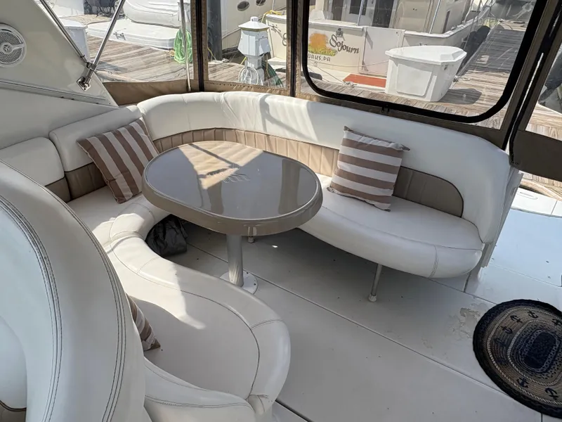 Slide: The Image of 2005 Four Winns 328 Vista Cruiser interior with curved seating and striped pillows. - 3