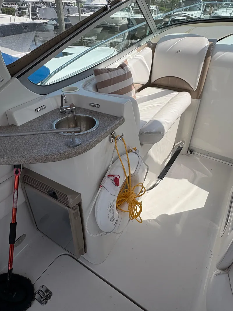 Slide: The Image of 2005 Four Winns 328 Vista Cruiser interior with sink, seating, and striped pillow. - 4