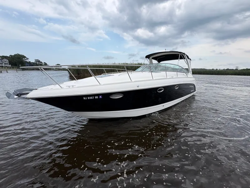Slide: The Image of 2006 Chaparral Signature 350 boat cruising on a calm lake with lush greenery. - 2