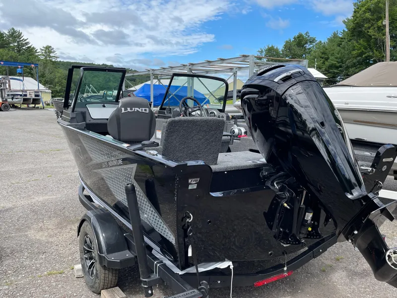 Slide: The Image of 2026 Lund 1675 Adventure Sport boat with outboard motor in a marina setting. - 10