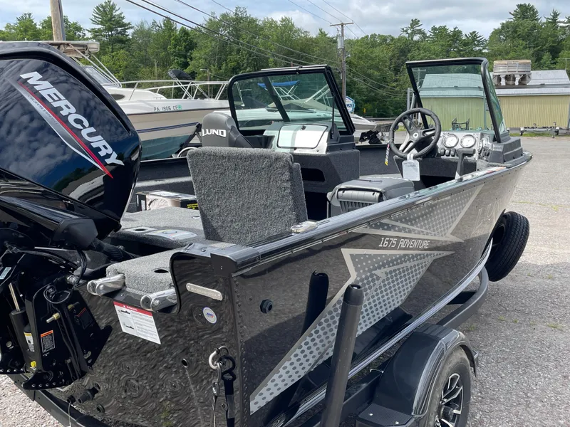 Slide: The Image of 2026 Lund 1675 Adventure Sport boat with Mercury engine, parked outdoors. - 12