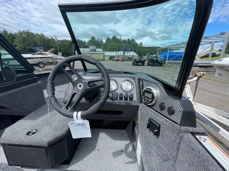 Slide: The Image of 2026 Lund 1675 Adventure Sport boat dashboard with steering wheel and gauges. - 7