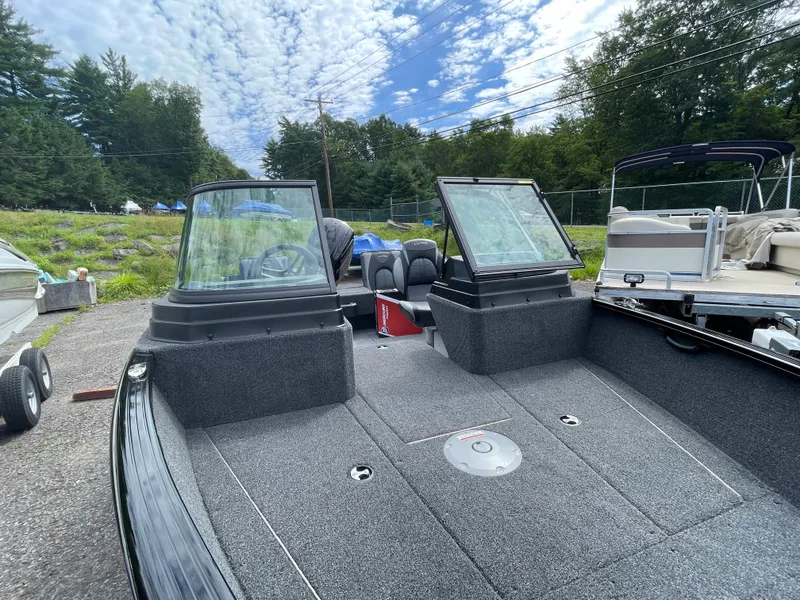 Slide: The Image of 2026 Lund 1675 Adventure Sport boat with open deck and windshield, surrounded by trees. - 8