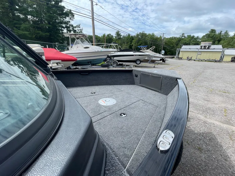 Slide: The Image of 2026 Lund 1675 Adventure Sport boat, parked outdoors, showcasing spacious deck and sleek design. - 9