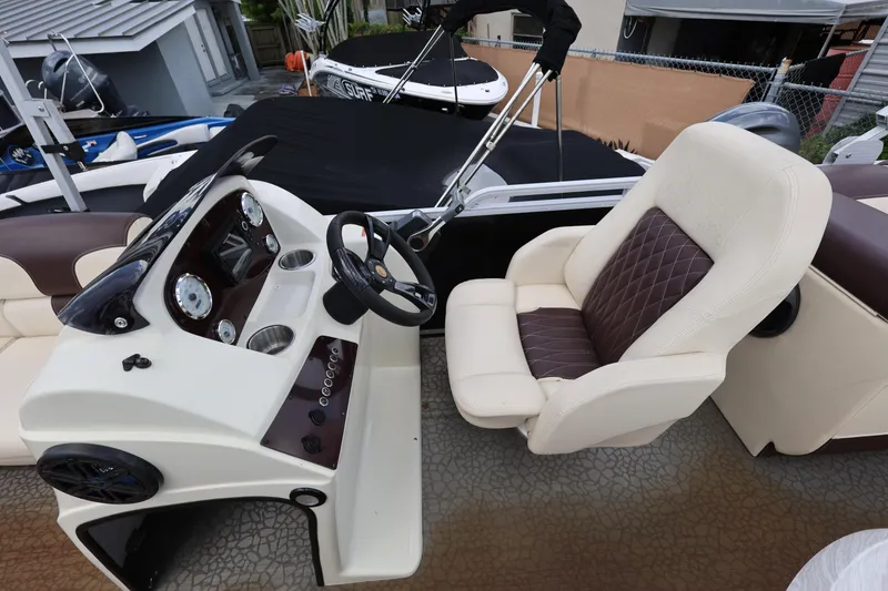 Slide: The Image of 2021 Lexington 525 cc boat interior with steering console and cushioned seating. - 13