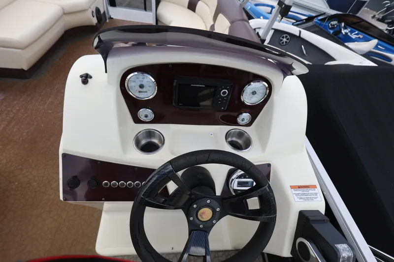 Slide: The Image of 2021 Lexington 525 cc boat dashboard with steering wheel and gauges. - 15